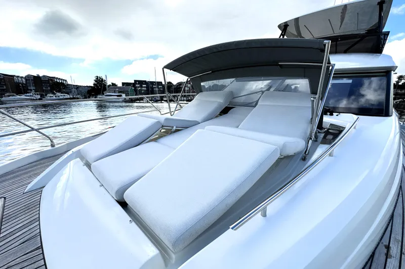 Slide: The Image of Luxurious 2023 Prestige 520 yacht with sun loungers on deck, docked by the waterfront. - 37