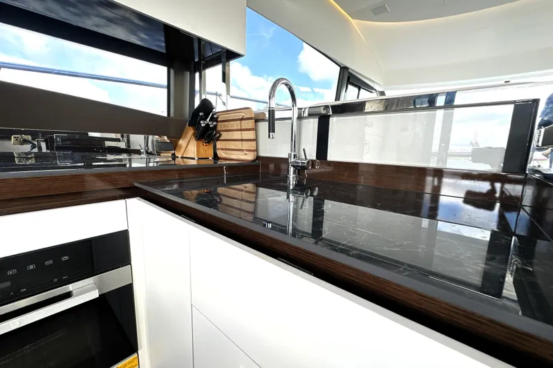 Slide: The Image of Modern kitchen interior on 2023 Prestige 520 yacht with sleek countertops and stainless steel fixtures. - 43