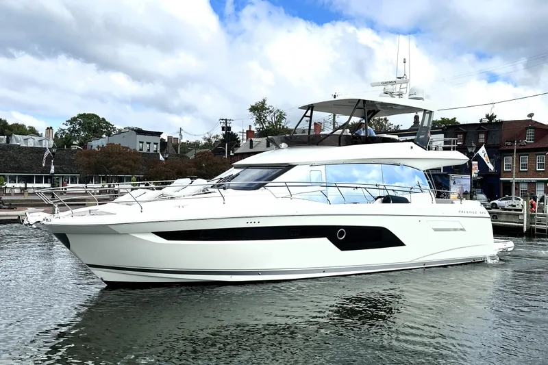 Slide: The Image of 2023 Prestige 520 yacht docked in a scenic harbor with cloudy skies. - 5