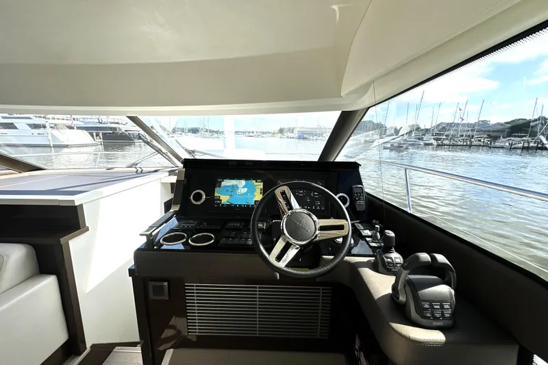Slide: The Image of Helm of 2023 Prestige 520 yacht with navigation display and marina view. - 52