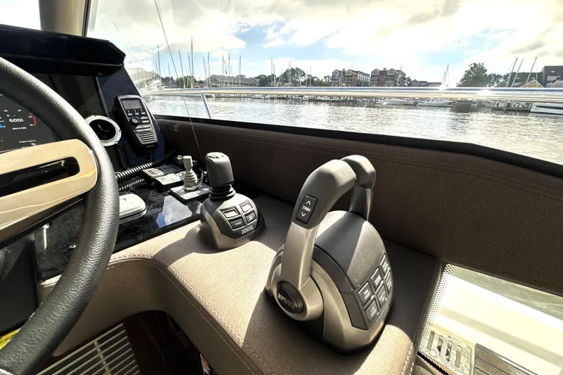 Slide: The Image of Cockpit of 2023 Prestige 520 yacht with steering controls and marina view. - 53