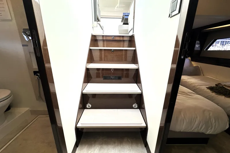 Slide: The Image of Staircase inside 2023 Prestige 520 yacht, leading to luxurious cabin and bathroom. - 64