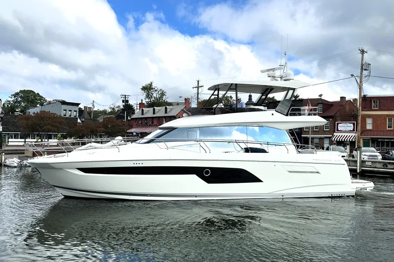 Slide: The Image of 2023 Prestige 520 yacht docked in a scenic harbor with cloudy sky. - 7