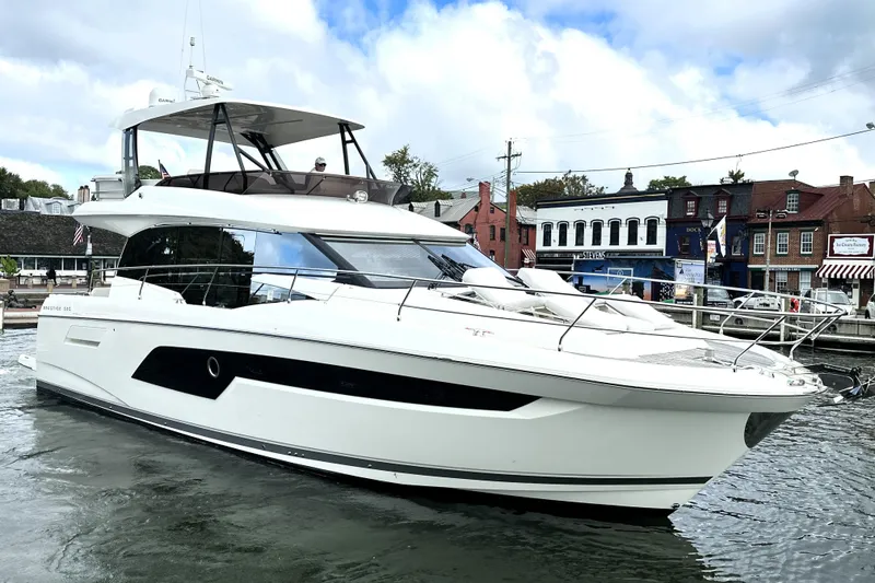 Slide: The Image of 2023 Prestige 520 yacht docked in a scenic harbor with historic buildings. - 8