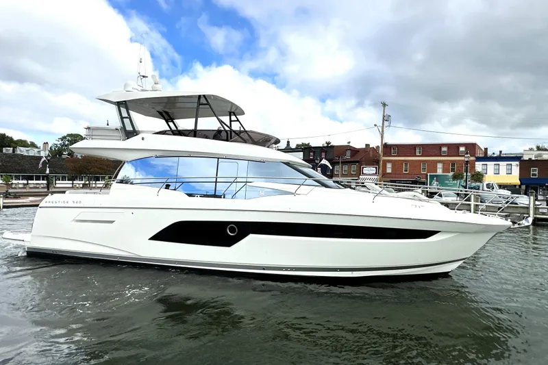 Slide: The Image of 2023 Prestige 520 yacht docked in a marina under cloudy skies. - 9