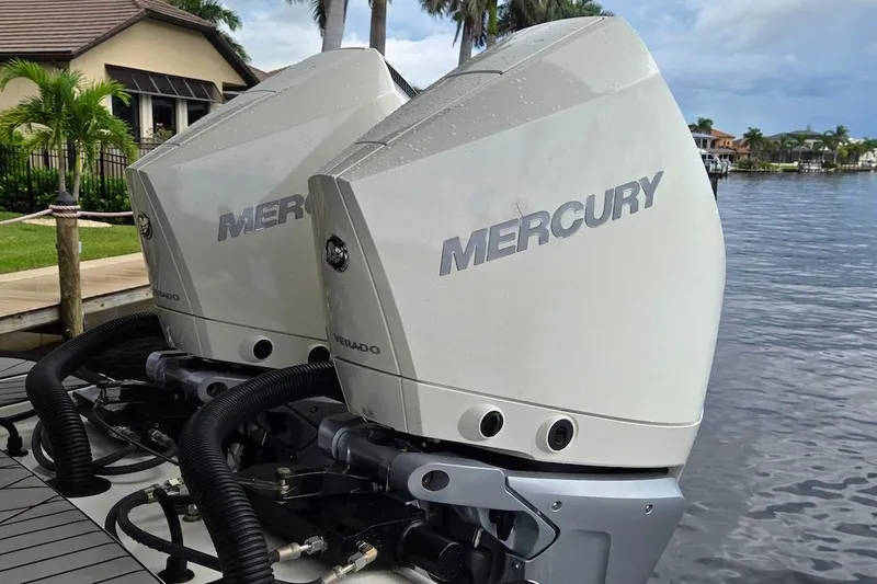 Slide: The Image of Twin Mercury outboard engines on a 2023 Sea Ray SLX 280, docked by a waterfront home. - 16