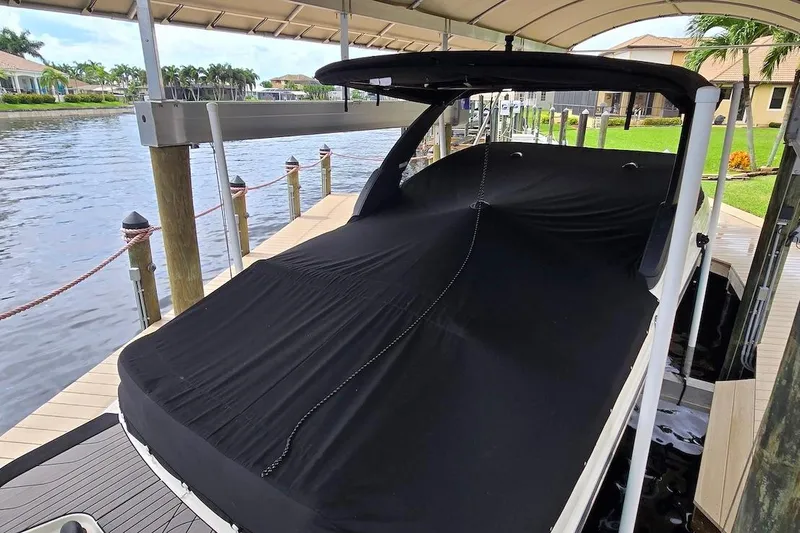 Slide: The Image of 2023 Sea Ray SLX 280 Outboard covered at dockside, under canopy. - 18