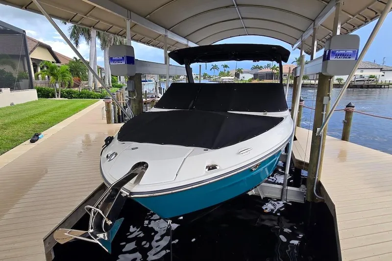 Slide: The Image of 2023 Sea Ray SLX 280 Outboard boat docked under a canopy on a sunny day. - 20