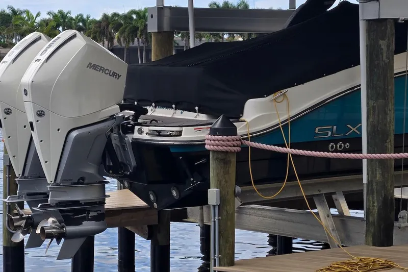 Slide: The Image of 2023 Sea Ray SLX 280 Outboard with Mercury engines docked on a lift. - 24