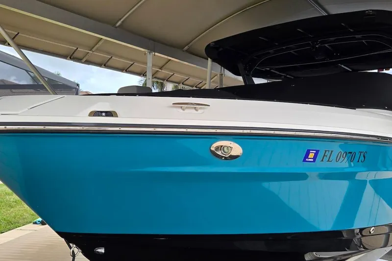 Slide: The Image of 2023 Sea Ray SLX 280 Outboard boat with blue hull, docked under a canopy. - 28