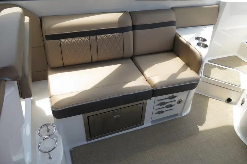 Slide: The Image of 2016 Sea Ray 280 SLX boat interior with beige seating and cup holders. - 5