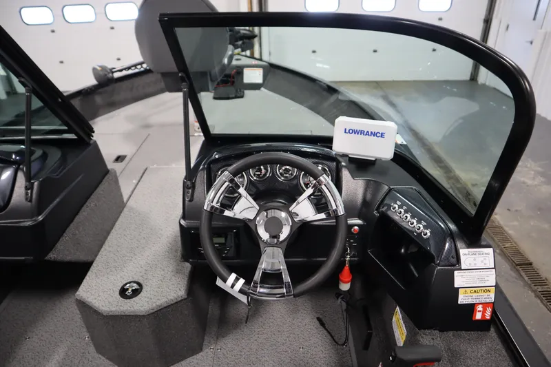 Slide: The Image of 2026 Lowe Fishing Machine 175 dashboard with steering wheel and Lowrance navigation system. - 23