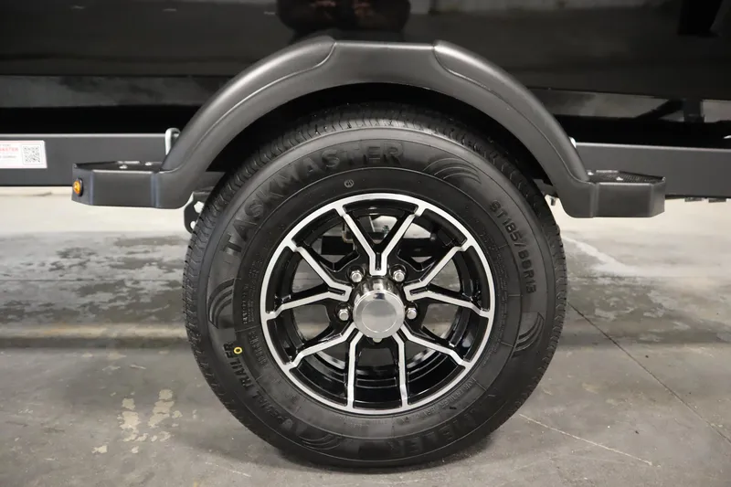 Slide: The Image of Trailer wheel of 2026 Lowe Fishing Machine 175, featuring black alloy rim. - 49
