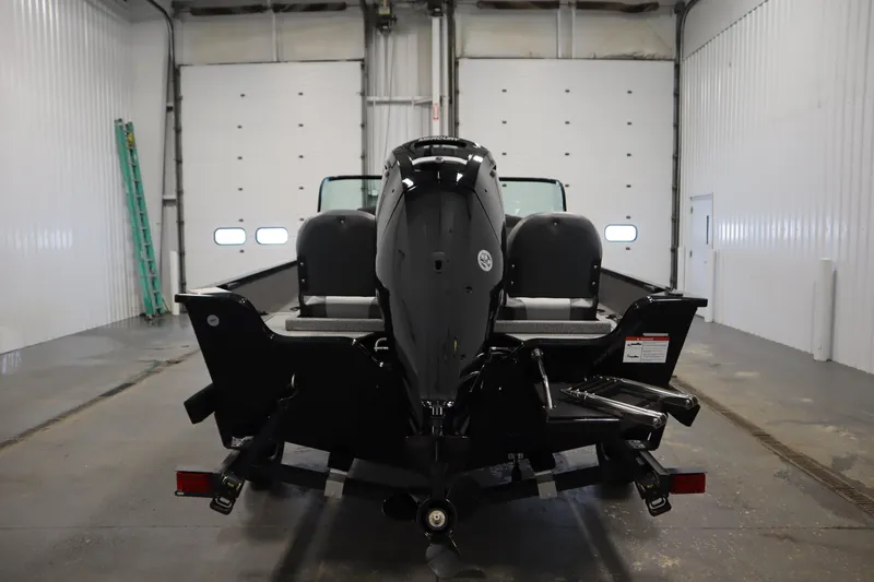 Slide: The Image of 2026 Lowe Fishing Machine 175 in a garage, rear view of the boat and motor. - 5