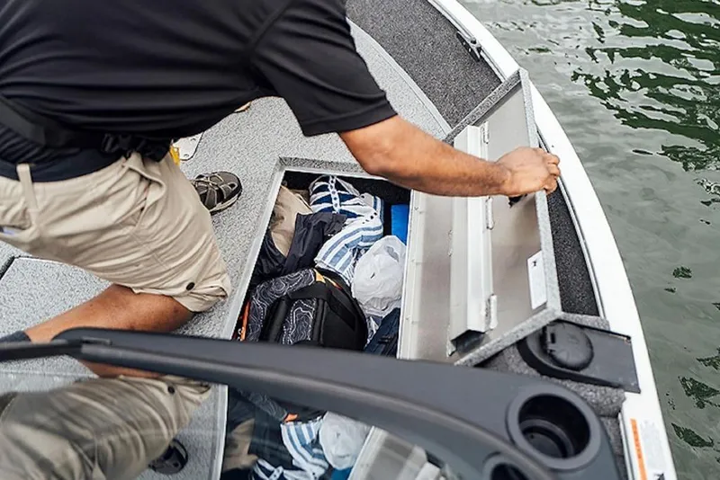 Slide: The Image of Man accessing storage on 2026 Lowe Fishing Machine 175 boat. - 57