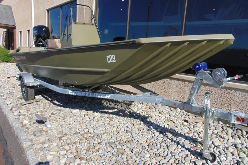 Slide: The Image of 2026 Crestliner 1860 Retriever CC boat on trailer, parked on gravel. - 12