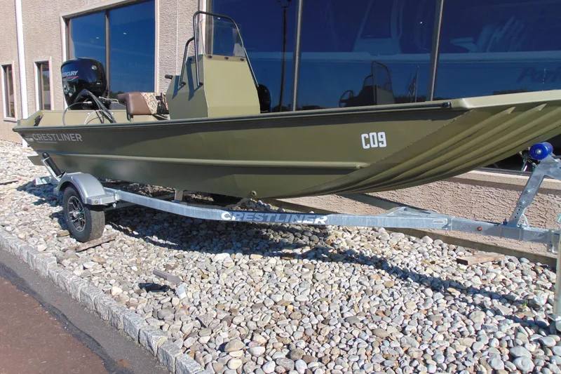 Slide: The Image of 2026 Crestliner 1860 Retriever CC boat on trailer, parked on gravel. - 13