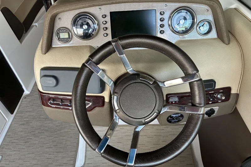 Slide: The Image of Steering wheel and dashboard of 2014 Regal 2500 Bowrider boat, featuring gauges and controls. - 12