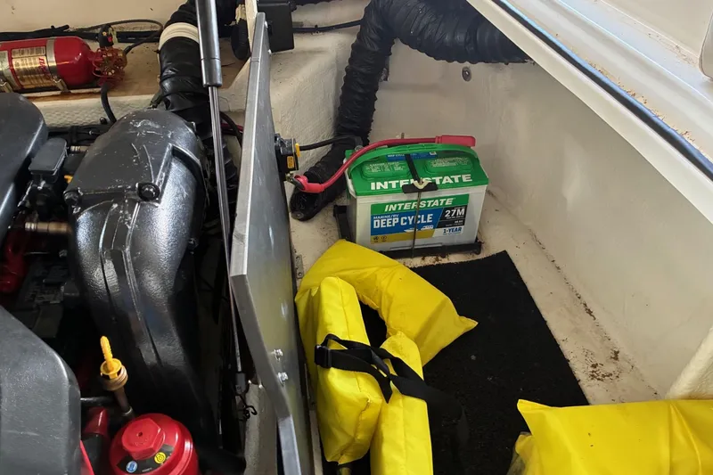 Slide: The Image of Engine compartment of 2014 Regal 2500 Bowrider with battery, fire extinguisher, and life jackets. - 21