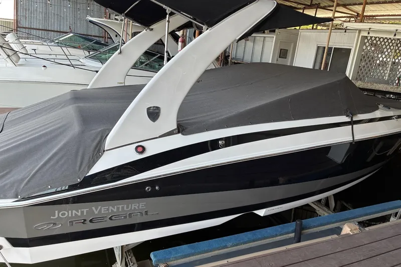 Slide: The Image of 2014 Regal 2500 Bowrider boat with cover, docked in a marina. - 4