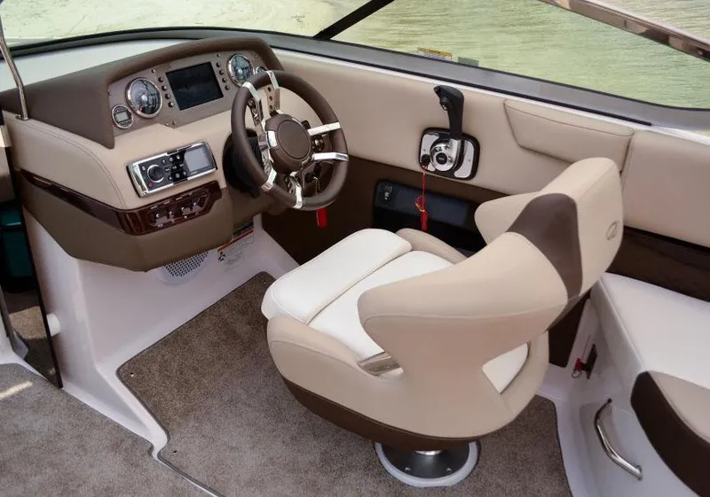 Slide: The Image of Manufacturer Provided Image: 2014 Regal 2500 Bowrider helm with beige and brown captain's seat, steering wheel, and control panel. - 6