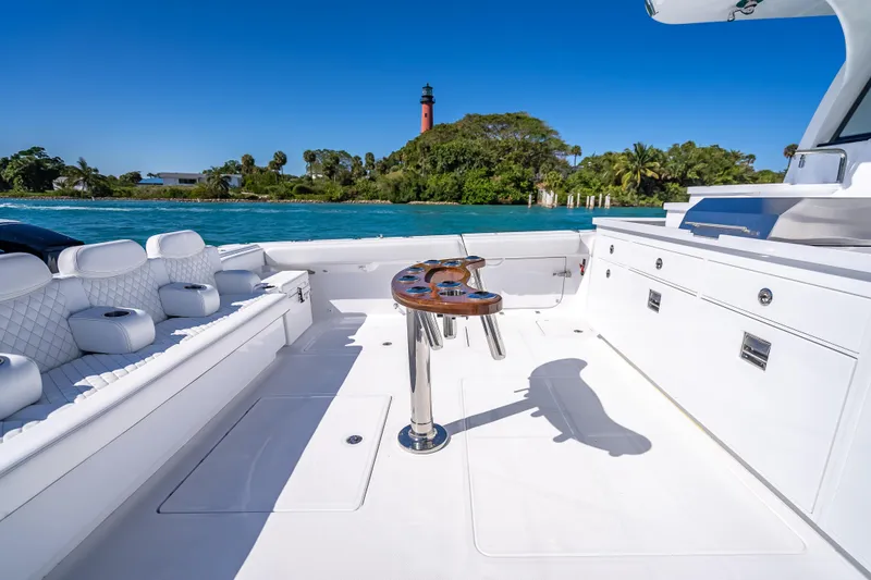 Slide: The Image of Luxurious 2026 HCB 65 Estrella yacht deck with seating, table, and scenic ocean view. - 13
