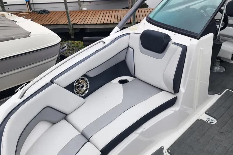 Slide: The Image of 2015 Yamaha Boats 212X interior with sleek white and gray seating, cup holder, and speaker. - 15