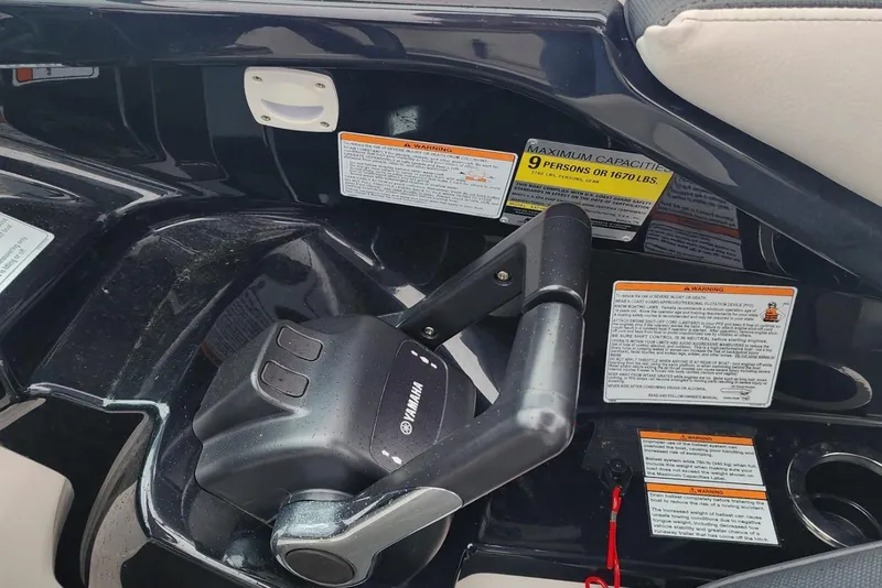 Slide: The Image of Control panel of a 2015 Yamaha Boats 212X with capacity and warning labels. - 25