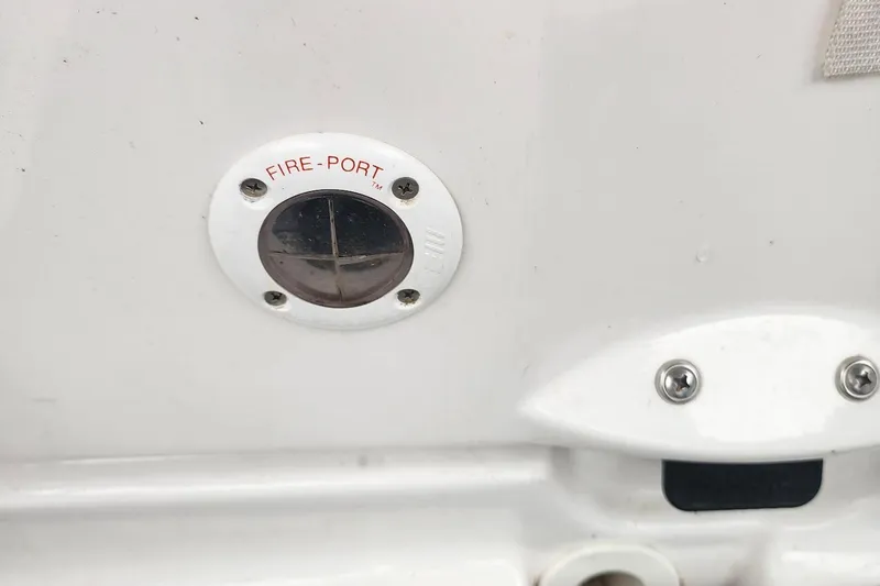 Slide: The Image of Fire-port on 2015 Yamaha Boats 212X, white surface with screws and label. - 33