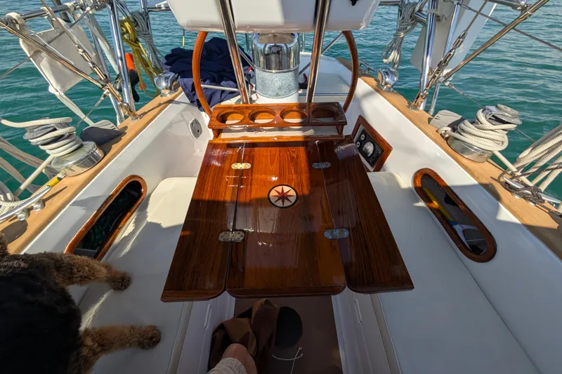 Slide: The Image of 1982 Shannon Pilothouse cockpit with wooden table, nautical equipment, and ocean view. - 12