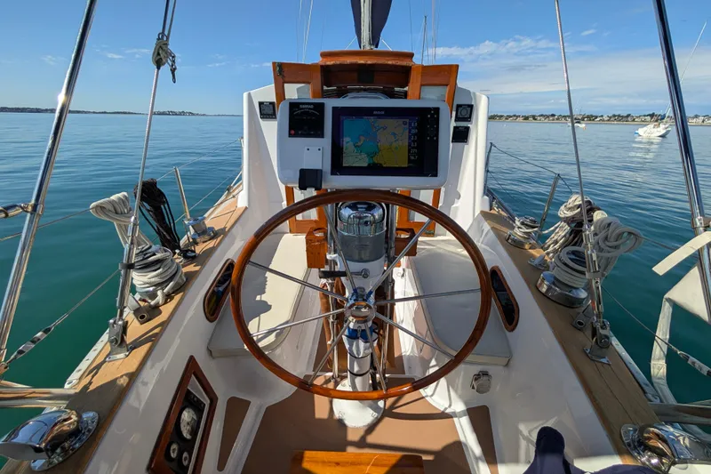 Slide: The Image of Cockpit of 1982 Shannon Pilothouse sailboat with navigation equipment on calm water. - 13