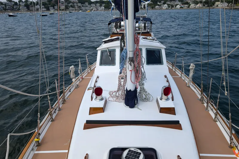 Slide: The Image of 1982 Shannon Pilothouse sailboat deck with ropes and coastal view. - 21