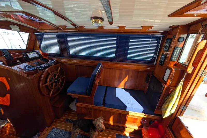 Slide: The Image of 1982 Shannon Pilothouse interior with wooden helm, blue cushions, and nautical instruments. - 4