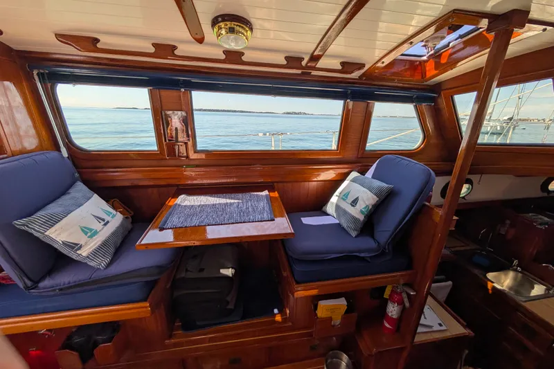 Slide: The Image of Interior of 1982 Shannon Pilothouse boat with blue cushions and ocean view. - 7
