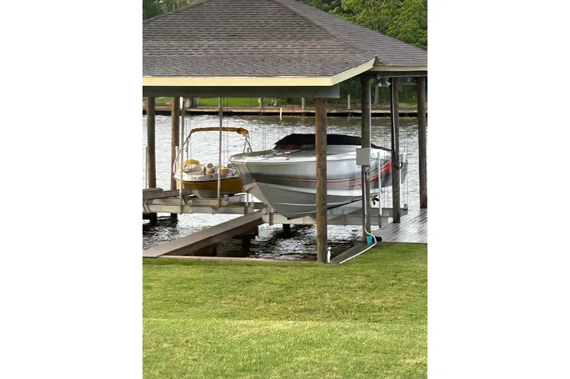 Slide: The Image of 2007 Donzi 38 ZR boat docked under a covered structure by the water. - 14