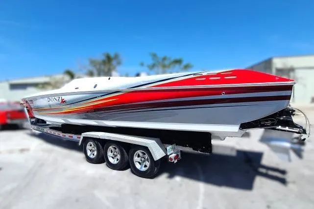 Slide: The Image of 2007 Donzi 38 ZR speedboat on trailer, featuring vibrant red and white design. - 2