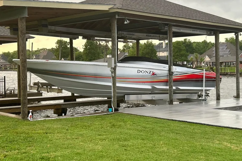 Slide: The Image of 2007 Donzi 38 ZR speedboat docked under a covered pier on a lake. - 4