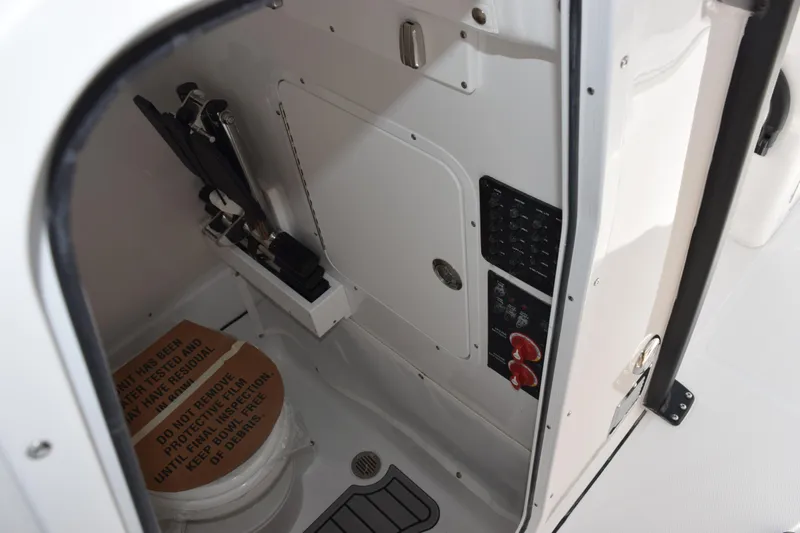 Slide: The Image of Interior of 2026 Sea Hunt Ultra 275 SE boat, featuring a compact restroom area. - 18
