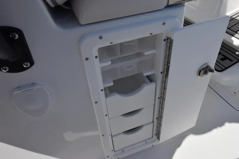 Slide: The Image of Open storage compartment on 2026 Sea Hunt Ultra 275 SE boat, featuring organized shelves. - 22