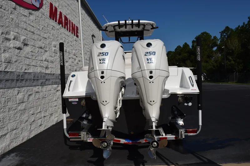 Slide: The Image of 2026 Sea Hunt Ultra 275 SE boat with dual 250 V6 engines, parked outside a marine store. - 5
