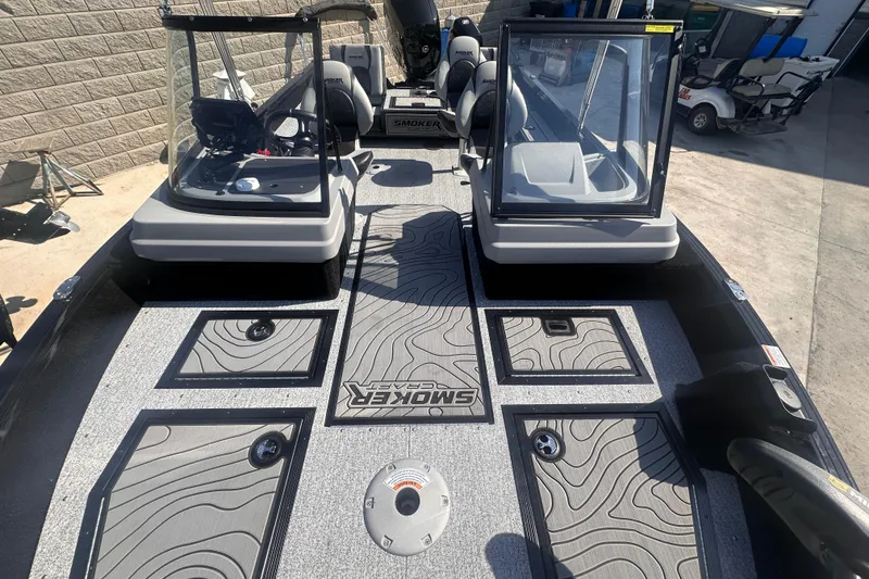 Slide: The Image of 2026 Smoker Craft Adventurer 188 DC boat interior with open windshield and patterned flooring. - 8