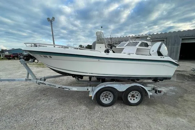 Slide: The Image of 1994 Wahoo 2050 EFS boat on trailer, parked outdoors under cloudy sky. - 3