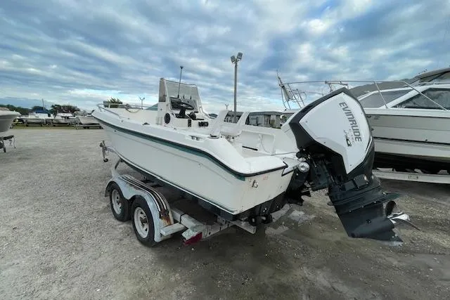 Slide: The Image of 1994 Wahoo 2050 efs boat on trailer with Evinrude outboard motor, parked outdoors. - 4