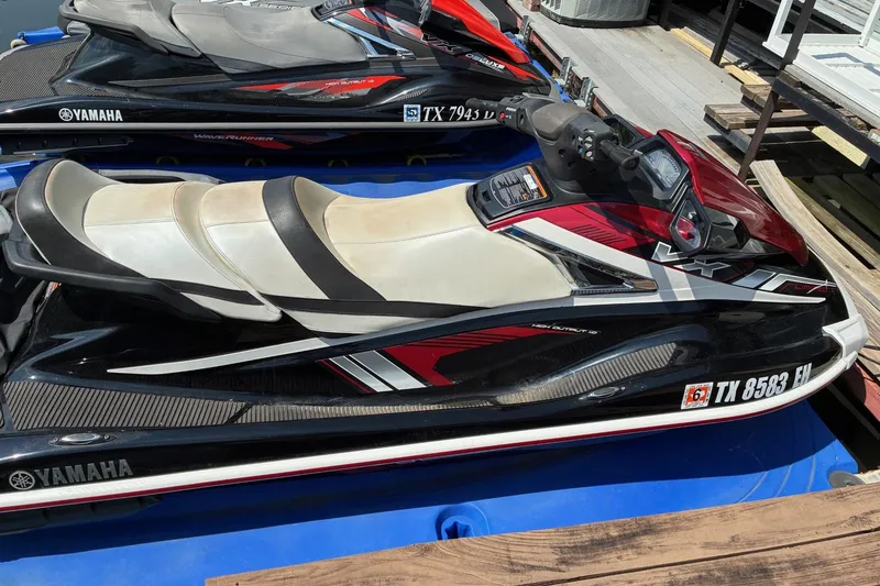 Slide: The Image of 2018 Yamaha WaveRunner VX Limited jet ski with red and black design, docked on a platform. - 2