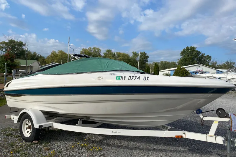 Slide: The Image of 1999 Ebbtide 2300 Bow Rider boat on trailer, covered, parked outdoors. - 2