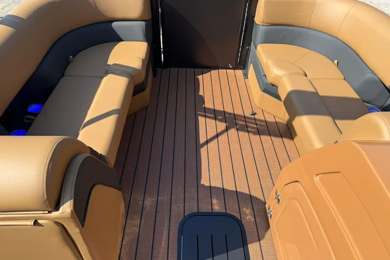 Slide: The Image of 2025 Bentley Pontoons Elite 223 Swingback interior with tan seating and wood-style flooring. - 5