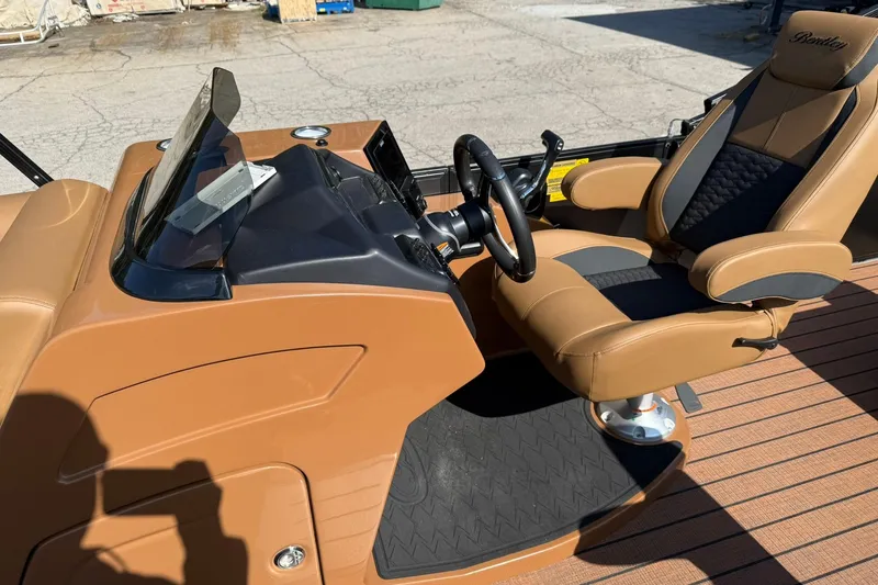 Slide: The Image of 2025 Bentley Pontoons Elite 223 Swingback helm with luxurious tan seating and sleek dashboard. - 9