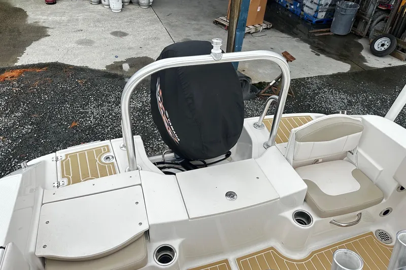 Slide: The Image of 2017 Robalo R180 Center Console boat with Yamaha engine cover, docked on gravel. - 12