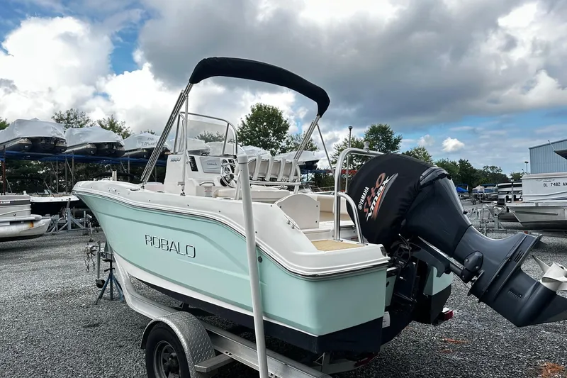 Slide: The Image of 2017 Robalo R180 Center Console boat with Yamaha engine on trailer, under cloudy sky. - 2