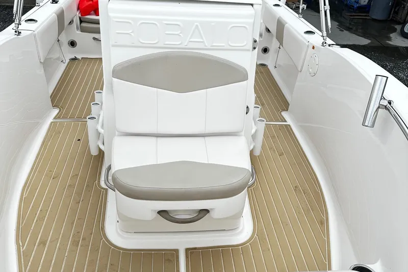 Slide: The Image of 2017 Robalo R180 Center Console boat interior with cushioned seating and teak-style flooring. - 8